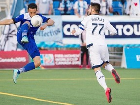 Vancouver Whitecaps’ Pedro Morales (77) battles for the ball with Edmonton FC’s Cristian Raudales (7) during second half action of the Amway Canadian Championship semifinal at Edmonton’s Clarke Stadium on May 20, 2015.