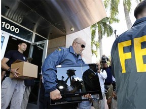 FBI agents carry boxes and computers from the headquarters of CONCACAF after it was raided on Wednesday in Miami Beach, Florida. The raid is part of an international investigation of FIFA where nine FIFA officials and five corporate executives were charged with racketeering, wire fraud and money laundering conspiracies.