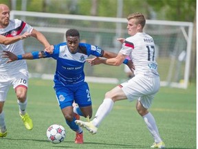Allan Zebie of FC Edmonton pushes off the Atlanta Silverbacks’ Hans Denissen and Michael Reed at the same time in an attempt to break free during a North American Soccer League game at Clarke Field on May 24, 2015.