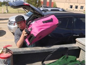 An Athabasca resident named Jordan moves his family's luggage at the temporary shelter at the Athabasca University Multiplex for citizens of Wabasca who were evacuated after a state of emergency was issued Sunday night due to wildfires in the area.