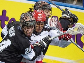 Calgary Roughnecks’ Jeff Shattler is caught in the middle between Edmonton Rush defenceman Ryan Dilks and an unidentified teammate during a National Lacrosse League playoff game at Rexall Place on May 15, 2015.