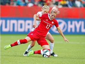 Canada’s Sophie Schmidt and New Zealand’s Betsy Hassett battle Thursday for the ball during second half FIFA Women’s World Cup soccer action in Edmonton.