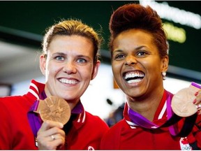 Canadian women’s soccer team captain Christine Sinclair laughs with coach John Herdman, right, and organizing committee member Victor Montagliani during a FIFA news conference on Dec. 5, 2014, in Ottawa.