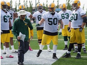 Edmonton Eskimos offensive line coach Mike Scheper works with rookie Danny Groulx during training camp at Fuhr Sports Park in Spruce Grove on June 4, 2015.