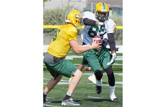 Edmonton Eskimos quarterback Matt Nichols gives the ball to receiver Marcus Rucker on a running play during a training camp session at Fuhr Sports Park in Spruce Grove on June 3, 2015.