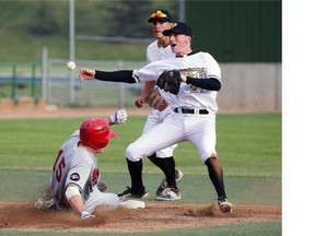 Edmonton Prospects' Tony Olson (right) throws the ball to first base as Medicine Hat Mavericks Aaron Green (right) slides to second base during Western Major Baseball League (WMBL) game action at Telus Field in Edmonton on May 30, 2015. Prospects' Derek Shedden is in background.