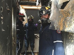 Fire investigator Kevin Bureau (front) and two other investigators examine a scene in north Edmonton.
