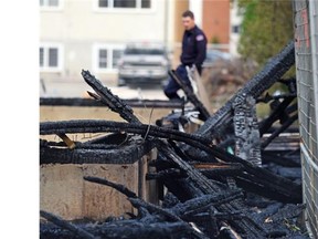 Fire investigators look over the scene after an under-construction duplex was destroyed in an early morning fire at 123rd Street and 117th Avenue in Edmonton on Wednesday, May 27, 2015.