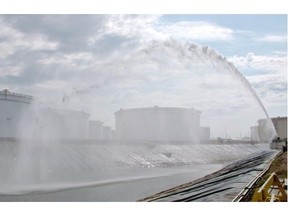 Firefighters spray water to simulate extinguishing a tank fire at the Kinder Morgan Edmonton Terminal on Wednesday, June 10, 2015. The full-scale exercise involved more than 200 personnel and was Kinder Morgan’s largest fire exercise to date. The tank farm is the initiating point for the Trans Mountain pipeline system.