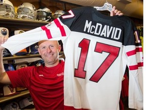 Kelly Hodgson of United Cycle in Edmonton holds up a Connor McDavid Team Canada jersey. United Cycle says it can't sell licensed replica Oilers jerseys with McDavid's name on it until he's drafted.