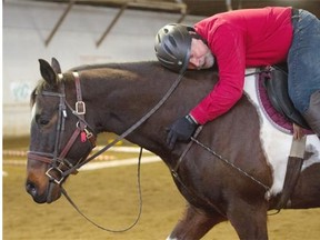 Locke Boros, 65, gives his horse a hug at the end of the lesson at Whitemud Equine Learning Centre.