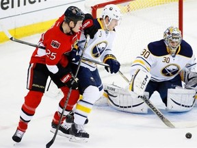 Mark Pysyk of the Buffalo Sabres tries to keep Ottawa Senators’ Chris Neil away from the net and Buffalo goalie Ryan Miller during a National Hockey League game at the Canadian Tire Centre in Ottawa on Dec. 12, 2013.