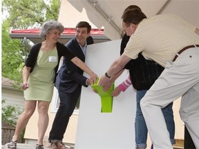 Mayor Don Iveson flips a ceremonial switch with homeowners Roberta Franchuk (left), Dietmar Kennepohl and their daughters (not visible) Inka and Astid Kennepohl, to signify hooking the solar panels into the grid in the Natural Resources Canada R-2000 Net Zero Energy Pilot House on May 29, 2015.