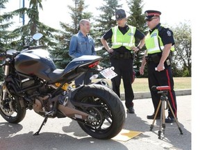 The Edmonton Police Service pulled over motorcycle riders at the NAIT Souch Campus on Sunday June 7, 2015 to test the exhaust sound levels from their motorbikes. It was an educational check stop to encourage riders to get their exhaust measured for sound to avoid getting a traffic ticket. In this photo, Roberto Santoro (left) speaks with EPS members Sgt. Eric Theuser (right) and Constable Kyle Westergaard (middle).