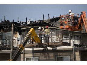 Workers carefully dismantled roof sections on Monday May 25, 2015 after fire raced through a condominium complex in northeast Edmonton the previous Friday, causing $16.3 million in damages.
