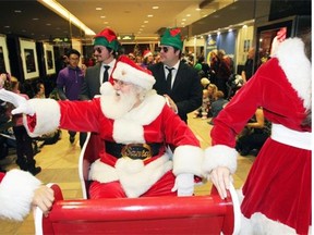 Santa waves to children as he travels through the annual Jingle On Indoor Santa Claus Parade in downtown Edmonton on Dec. 1, 2013. An outdoor parade, Santa’s Parade of Lights, will replace the indoor parade, which was cancelled after the 2013 edition.