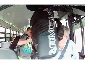 Screen capture from a video showing an incident on a school bus on May 25, 2015, where a student hits the bus driver in the face with a bag