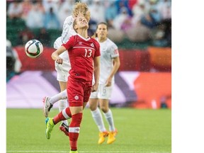 Sophie Schmidt (13) of Canada, battles with Betsy Hassett (12) of New Zealand, at Commonwealth Stadium in the round robin of the FIFA Women’s World Cup in Edmonton before the game was delayed by weather.