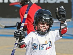 Tavin Vos, age six, celebrates Sunday after his team scored during the Play On! street hockey tournament at West Edmonton Mall. More than 600 teams participated.