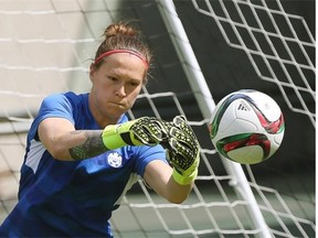 Team Canada goalkeeper Erin McLeod punches a ball away from the net during Friday’s practice at Commonwealth Stadium.