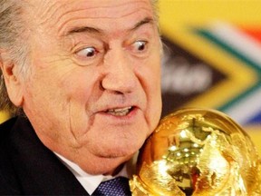 In this Sunday June 6, 2010 file photo FIFA President Joseph Blatter holds the trophy after receiving it back from South African President Jacob Zuma during a media briefing on the 2010 Soccer World Cup in Pretoria, South Africa.  FIFA President Sepp Blatter will resign from soccer's governing body amid a widening corruption scandal and promised Tuesday to call for fresh elections to choose a successor.