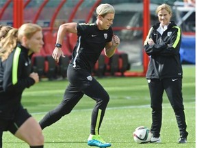 Abby Wambach (middle) and her United States teammates work hard during Sunday’s training session at Commonwealth Stadium.