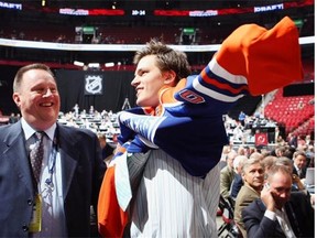 Anton Lander of the Edmonton Oilers puts on a team jersey  handed to him by Stu MacGregor after being drafted in the second round of the 2009 NHL entry draft at the Bell Centre in Montreal on June 27, 2009.