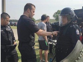 Const. Stephan Vachon-Zee helps Robert Haaf, 14, put on gear worn by riot officers during a camp at Oskayak Police Academy.