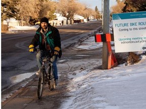 Dean Black rides past a sign along 95th Avenue near 156th Street in February 2013 in Edmonton announcing a new bike lane. Council conceded Tuesday the special lane was a failure.