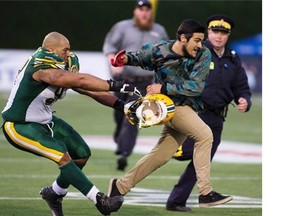 Edmonton Eskimo Ryan King (53) helped tackle a spectator that ran on the field during the preseason game against the Saskatchewan Roughriders on June 13 in Fort McMurray.