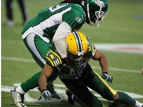 Edmonton Eskimos’ Eric Page (80) is pushed to the ground by Saskatchewan’s Junior Mertile during CFL pre-season action in Fort McMurray on Saturday. Page was one of seven players released by the Eskimos on Sunday, June 14, 2015.