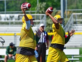 Edmonton Eskimos quarterbacks Matt Nichols, left, and James Franklin appear to be executing a synchronized passing drill during a practice at Fuhr Sports Park in Spruce Grove on June 24, 2015.