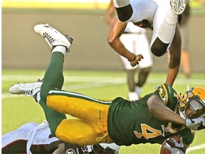 Edmonton Eskimos slotback Adarius Bowman goes low after making a catch while Ottawa Redblacks defensive back Abdul Kanneh flies over him during Wednesday’s Canadian Football League game at Commonwealth Stadium.