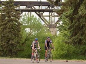 From left, Julia LeConte takes a ride through the river valley with Brian Countryman, from the Edmonton Masters Cycling Club, with the High Level Bridge in the background.