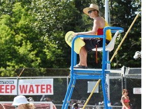 Head lifeguard Scott Bell uses a straw hat to try and stay cool at Mill Creek Pool on a hot day in Edmonton on Thursday July 9, 2015.