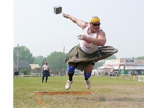 Jason Johnston from White City, Sask., leaves the ground as he spins to throw a 56-pound weight 43-feet 1-inch in the weight for distance competition during the Highland Games at the Celtic Celebration in Fort Edmonton Park in Edmonton on July 11, 2015. Johnston went on to set a field record of 44 feet.