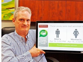John Putters, CEO of Visionstate, demonstrates the company’s touch panel for tracking washroom maintenance.