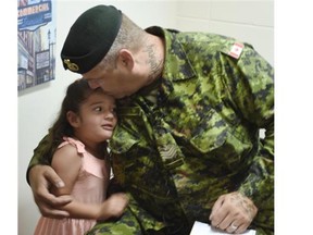 Sgt. Kevin Nanson with one of his daughters at a press conference about the injured soldiers’s housing situation in NDP MP Linda Duncan’s constituency office in Edmonton on Friday July 3, 2015.