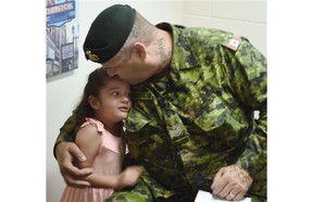 Sgt. Kevin Nanson with one of his daughters at a press conference about the injured soldiers’s housing situation in NDP MP Linda Duncan’s constituency office in Edmonton on Friday July 3, 2015.