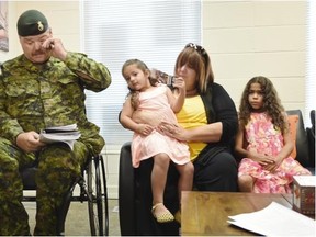 Sgt. Kevin Nanson with his wife Kim and daughter’s Molly-Jayde, 3, and Erin, 8, attend a press conference about the injured soldiers’s housing situation in NDP MP Linda Duncan’s constituency office in Edmonton on Friday July 3, 2015.