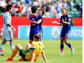 Larissa Crummer (2) of Australia watches as Ayumi Kaihori (18, Azusa Iwashimizu #3, Aya Miyama #8 and Rumi Utsugi #13 of Japan celebrate after defeating Australia during the FIFA Women’s World Cup quarter-final match between Australia and Japan at Commonwealth Stadium on June 27.