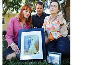 Linda-Rae Carson (L), Todd Walker and Kathie Peterson in 2013 hold a picture of their parents, Sheila and Allen Walker, who were killed when a tow truck hit their vehicle.