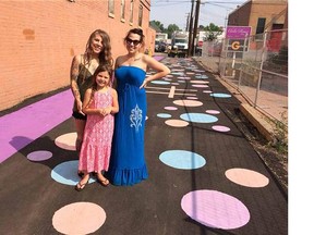 Chasity Parr, left, her daughter Kodie Irwin, 6, and Amanda Graham stand in the new pedestrian plaza in the north side of Whyte Avenue near 104th Street.
