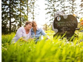 Marilyn Koren and her daughter Jamie Sullivan at the gravesite of Jamie’s daughter, Delonna Sullivan, near Warburg in July 2013. A fatality inquiry into the child’s death begins next week.