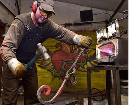 Slavo Cech, an artisan blacksmith, working in his shop Sunday using his 1,300 C forge, working on a railing component in Edmonton, June 28, 2015.