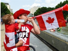 Nick Stevens and his son Silas, 9 months, were enthusiastic as thousands of people turned up for Canada Day celebrations at the Provincial Legislature in Edmonton on Wednesday July 1, 2015.