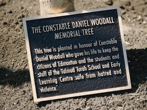 A plaque at the base of a sugar maple tree planted outside Talmud Torah School in west Edmonton, in memory of EPS Constable Daniel Woodall, who was shot and killed in the line of duty on June 8, 2015.