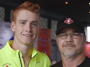 Pole vaulter Shawn Barber stands with his father, George, during a press conference in Edmonton in July 2015.