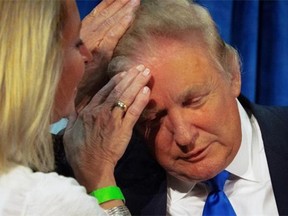 Republican presidential candidate Donald Trump asks N.H. House Rep. Claire Rouillard to confirm that his hair is real during a rally at Manchester Community College in Manchester, N.H., on Wednesday, June 17, 2015.