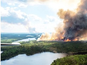Smoke and flames rise from a forest in the LaRonge, Sask., area in this July 1, 2015 handout photo from the Saskatchewan Ministry of Environment.